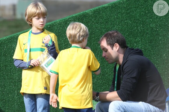 Joaquim e Benício com crachá e camiseta da seleção Brasileira, em um dos treinos do time