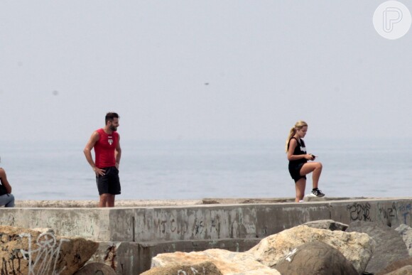 Henri Castelli se exercita com a namorada e mostra boa forma em mergulho na praia da Barra da Tijuca, no Rio