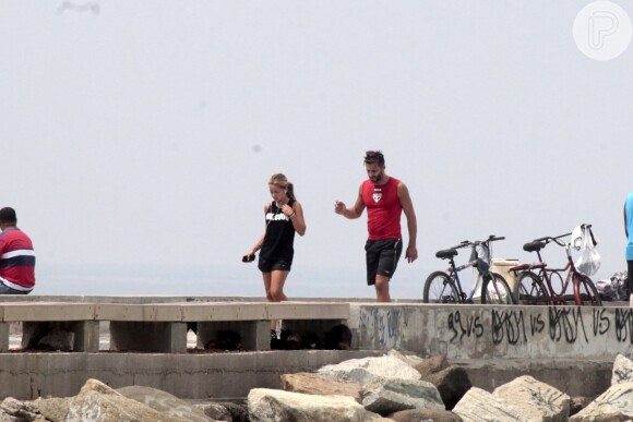 Henri Castelli se exercita com a namorada e mostra boa forma em mergulho na praia da Barra da Tijuca, no Rio