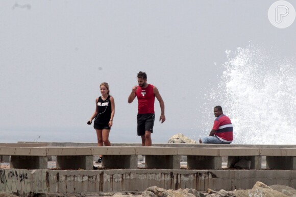 Henri Castelli se exercita com a namorada e mostra boa forma em mergulho na praia da Barra da Tijuca, no Rio