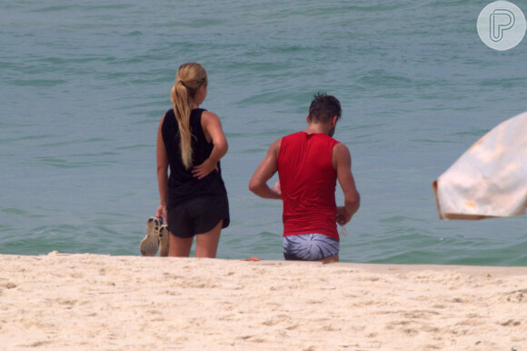 Henri Castelli se exercita com a namorada e mostra boa forma em mergulho na praia da Barra da Tijuca, no Rio