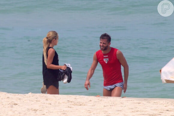Henri Castelli se exercita com a namorada e mostra boa forma em mergulho na praia da Barra da Tijuca, no Rio