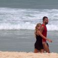 Henri Castelli se exercita com a namorada e mostra boa forma em mergulho na praia da Barra da Tijuca, no Rio