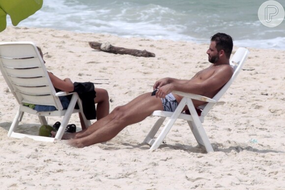 Henri Castelli se exercita com a namorada e mostra boa forma em mergulho na praia da Barra da Tijuca, no Rio