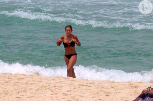 Henri Castelli se exercita com a namorada e mostra boa forma em mergulho na praia da Barra da Tijuca, no Rio