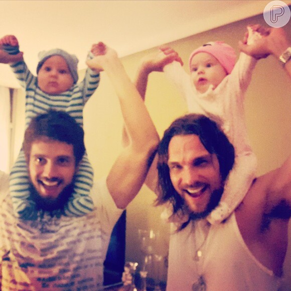 Rafael Cardoso e Igor Rickli publicaram foto na qual aparecem cada um com o filho do outro nos ombros
