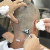 Após a máquina zero, a equipe de caracterização passa lâmina de barbear na cabeça de Sergio Marone 