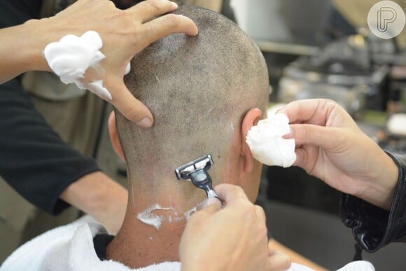 Após a máquina zero, a equipe de caracterização passa lâmina de barbear na cabeça de Sergio Marone 
