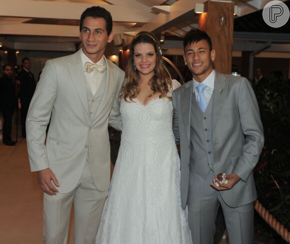 Padrinho de Ganso, Neymar é flagrado com a mão cheia de docinhos ao posar com os noivos. O casamento de Paulo Henrique Ganso aconteceu no sábado, 25 de maio de 2013,