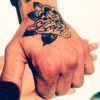 O casal de mãos dadas e a tatuagem do jogador escrito "Love"