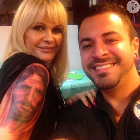 Monique Evans tatuou no braço direito uma imensa imagem do rosto de Jesus Cristo