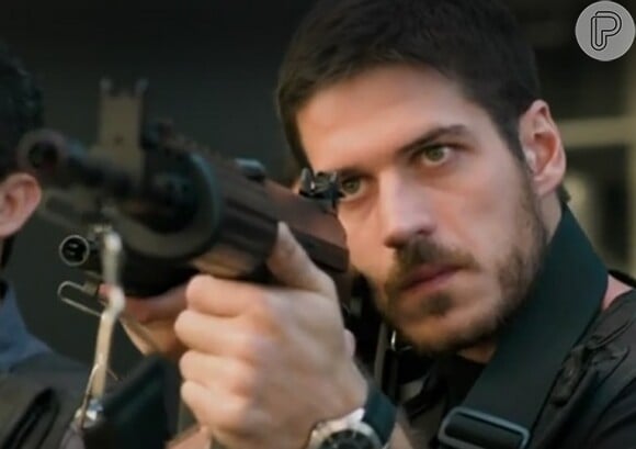 O policial justiceiro Dante (Marco Pigossi) mira o alvo em cena da nova chamada da novela 'A Regra do Jogo'