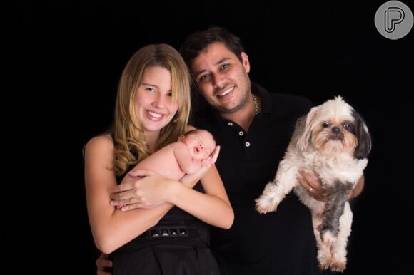 Debby Lagranha segura a filha, Maria Eduarda, e o marido, Leandro Franco, segura um cachorro