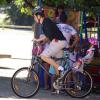 Depois de muita diversão, Mateus Solano deixa o local com Flora sentada na garupa da bicicleta e seguem para casa