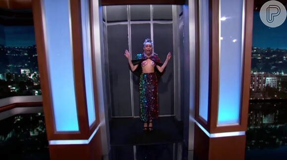 No palco do programa de Jimmy Kimmel, Miley Cyrus também apareceu com figurino ousado. A cantora escolheu uma roupa brilhosa e deixou parte dos seios à mostra, cobrindo os mamilos com dois adesivos de coração