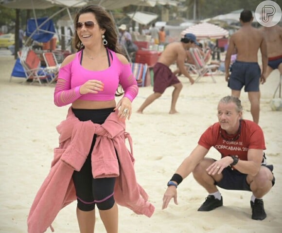 Intérprete da figurante Mel em 'A Regra do Jogo', Fernanda Souza gravou cenas da novela na praia ao lado de Marcello Novaes