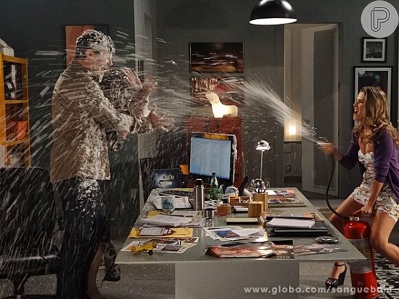Tina (Ingrid Guimarães) dispara a espuma de um extintor de inscêndio contra Damáris (Marisa Orth) e Vitinho (Rodrigo Lopez), em cena de 'Sangue Bom'