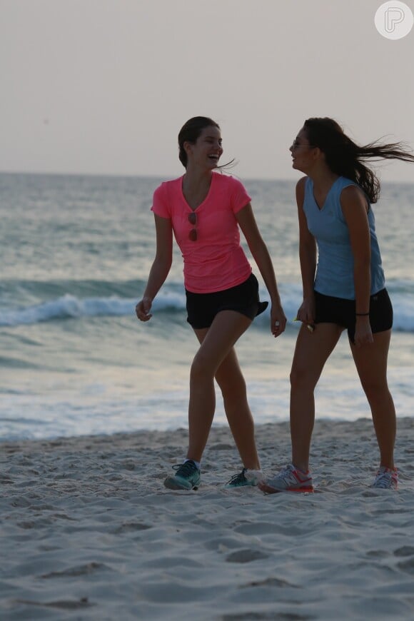 Camila Queiroz conversa com amiga durante caminhada na orla da praia da Barra