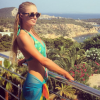 A socialite Paris Hilton escolheu maiô verde-água frente única para dia de sol em Ibiza