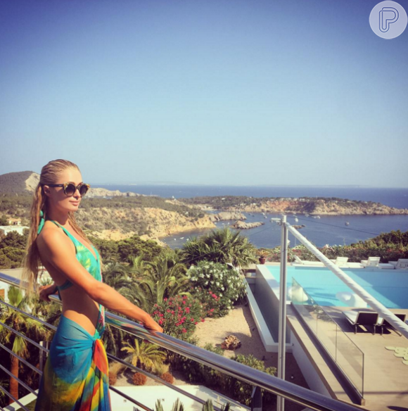 A socialite Paris Hilton escolheu maiô verde-água frente única para dia de sol em Ibiza