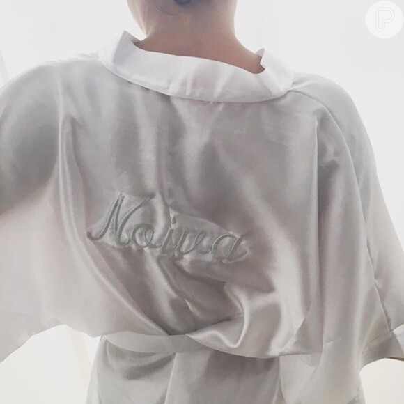 Em um clique que está rodando o Instagram, Sophie Charlotte aparece de costas, usando um hobby branco onde se lê a palavra 'Noiva'