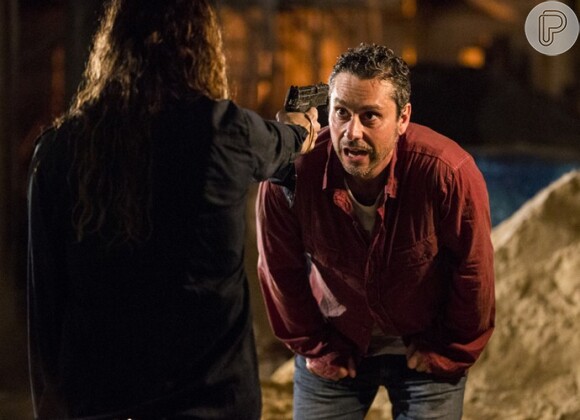Atena (Giovanna Antonelli) consegue tirar o revólver de Romero (Alexandre Nero) e o aponta para ele mas o advogado não acredita que ela vai atirar, na novela 'A Regra do Jogo'