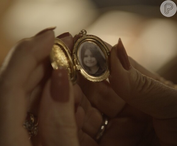 Vitória (Irene Ravache) mostra a foto da filha em seu pingente para Lívia (Alinne Moraes), na novela 'Além do Tempo'