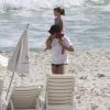 Daniel carrega a filha mais velha, Lara, nos ombros em praia carioca