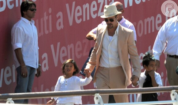 Brad Pitt caminha de mãos dadas com os filhos Pax, 8 anos, e Maddox, 11, na Itália, em 2008