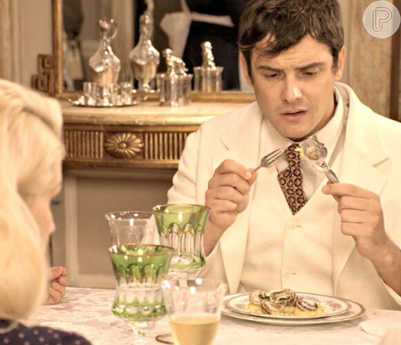Candinho (Sergio Guizé) se atrapalha com os talheres na hora de comer escargot, na novela 'Êta Mundo Bom!'