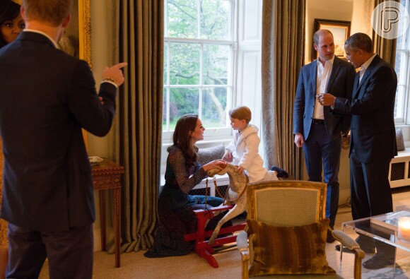 Em uma segunda foto, William e Obama conversam enquanto George brinca em um cavalinho de madeira e presta atenção a algo que sua mãe, Kate Middleton, diz a ele