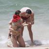 Mateus Solano e Paula Braun levaram Flora até o mar. O ator pegou uma conchinha nas mãos e mostrou para a filha
