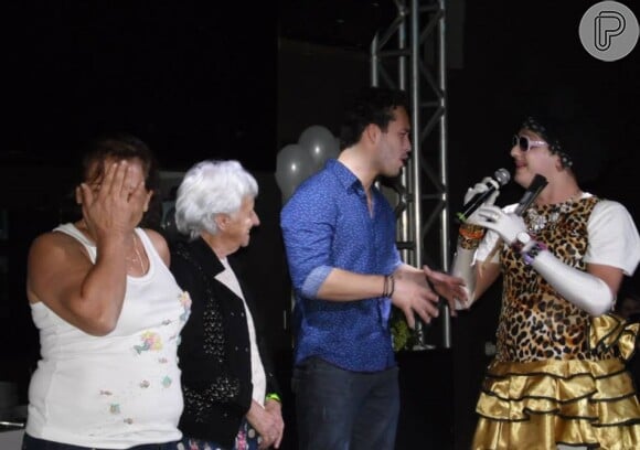 Rodrigo Andrade no palco ao lado da sogra, Dulcineia Alvares, e de uma convidada do evento
