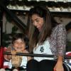 Juliana Paes sorri e come pipoca com o filho Pedro, de dois anos, em roda gigante de shopping da Zona Oeste do Rio, em 10 de novembro de 2013
