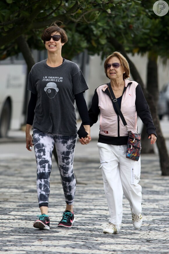 Maria Paula caminha acompanhada da mãe de mãos dadas