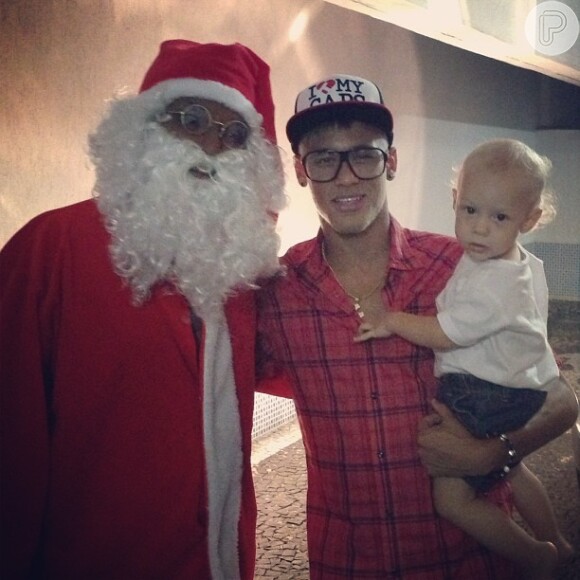 Neymar segura o filho, Davi Lucca, no colo e posa ao lado do Papai Noel no Natal
