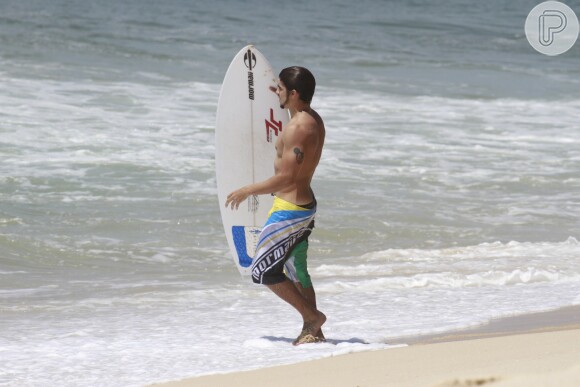 Caio Castro exibe boa forma ao surfar em praia carioca