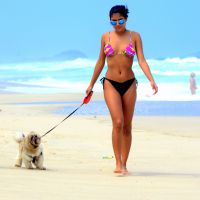 Ex-BBB Munik exibe boa forma de biquíni em praia ao passear com cachorro. Fotos!