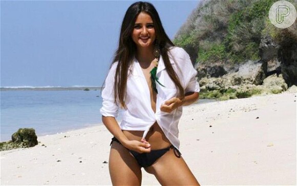 Catarina posa de bíquini em praia. Ela ficou conhecida depois de leiloar a virgindade na internet