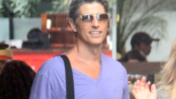 Reynaldo Gianecchini passeia sorridente acompanhado de amiga em shopping do Rio