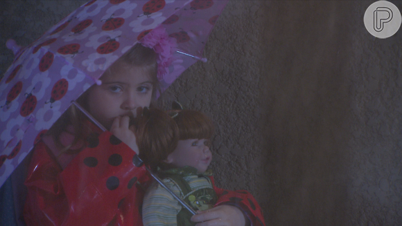 Dulce Maria (Lorena Queiroz), usando capa de chuva e segurando uma boneca,  foge de casa por se decepcionada com o pai, que sempre lhe coloca de castigo, no capítulo que vai ao ar terça-feira, dia 06 de dezembro de 2016, na novela 'Carinha de Anjo'