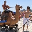 Anderson Di Rizzi e Daniel Rocha brincam com camelo de mentira em praia carioca
