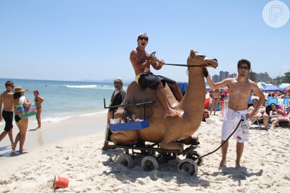 Anderson Di Rizzi e Daniel Rochabrincam com camelo de mentira nesta quinta-feira, 30 de janeiro de 2014, na praia da Barra da Tijuca, Zona Oeste do Rio de Janeiro