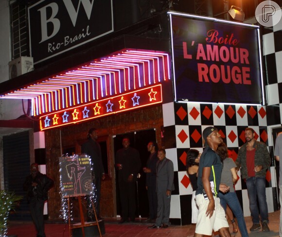 Cauã Reymond ao lado da boate cenográfica L'amour Rouge
