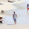 Ricky Martin caminha pela areia da praia do Diabo com cachorrinhos