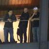 Russell Crowe ao lado de um amigo e segurança na sacada de hotel