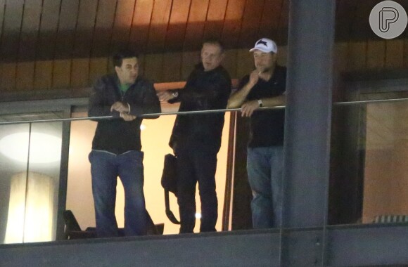 Russell Crowe ao lado de um amigo e segurança na sacada de hotel