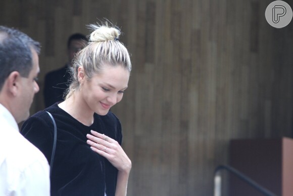 Candice Swanepoel sai sorridente de hotel em SP