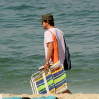 Marcelo Serrado vai à praia com a mulher e os filhos gêmeos