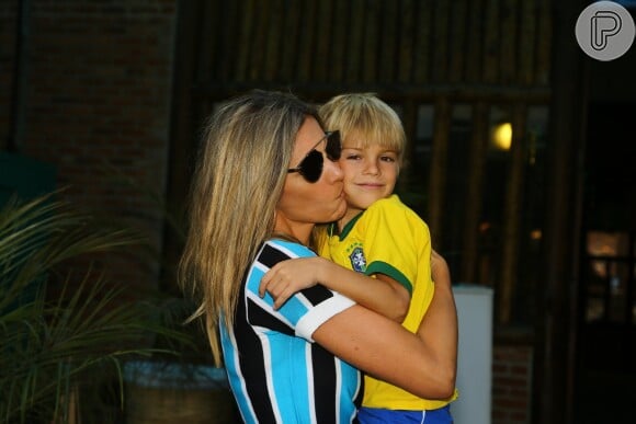 Fernanda Lima chegou à casa de festas com Francisco no colo e tascou um beijo no menino
